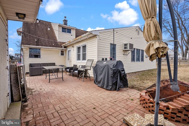 view of patio / terrace with a grill, fence, outdoor lounge area, and a wall mounted AC