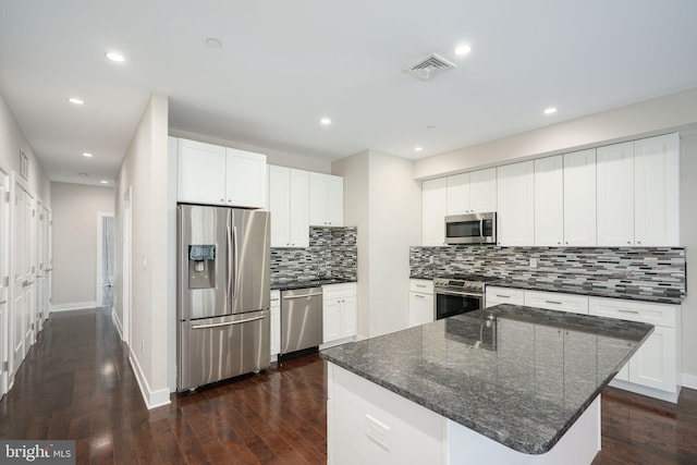 kitchen featuring decorative backsplash, visible vents, stainless steel appliances, and dark wood finished floors