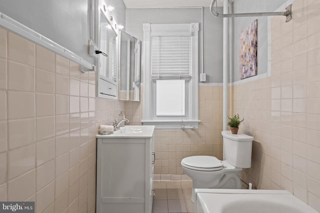 full bath with toilet, tile patterned flooring, vanity, and tile walls