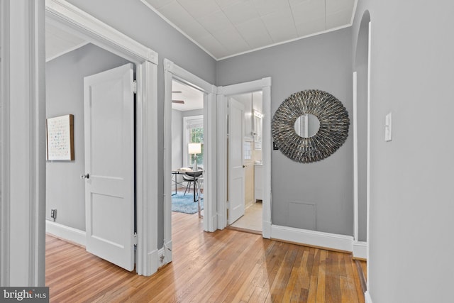 foyer featuring ornamental molding, light wood finished floors, and baseboards