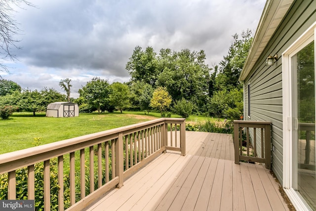 wooden deck with an outdoor structure, a lawn, and a shed