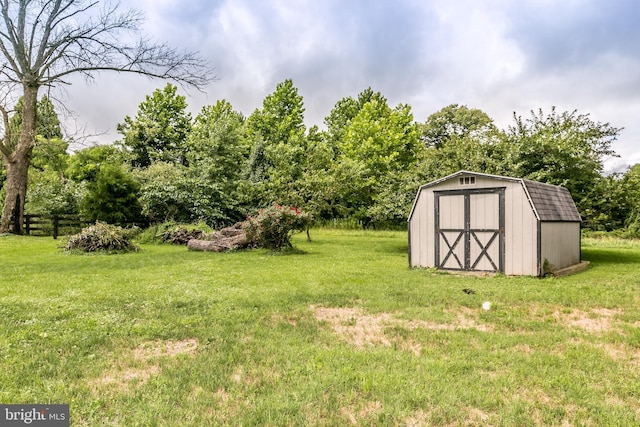 view of yard featuring an outbuilding, fence, and a storage unit