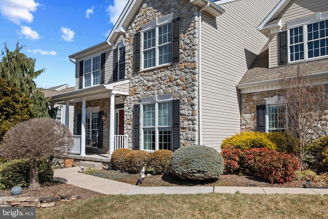 view of front of house with covered porch and stone siding