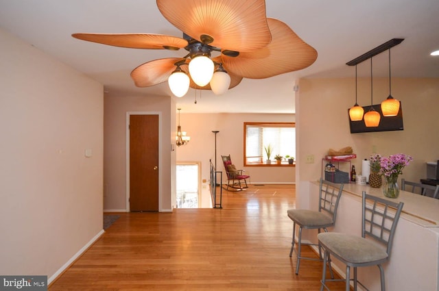 interior space featuring light wood-type flooring, baseboards, and a ceiling fan