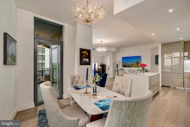 dining space with baseboards, an inviting chandelier, a wall of windows, light wood-style floors, and recessed lighting