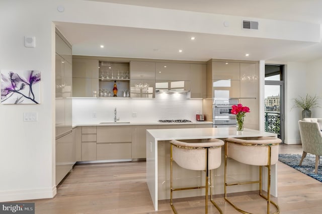 kitchen with gas cooktop, modern cabinets, a sink, and visible vents