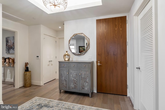 hallway featuring light wood-type flooring and baseboards