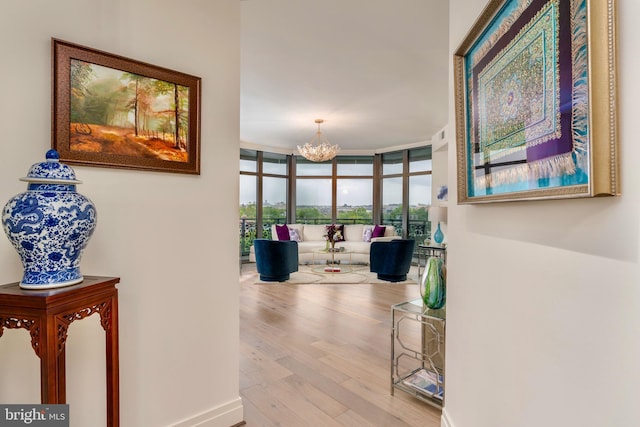 corridor featuring expansive windows, a notable chandelier, and wood finished floors