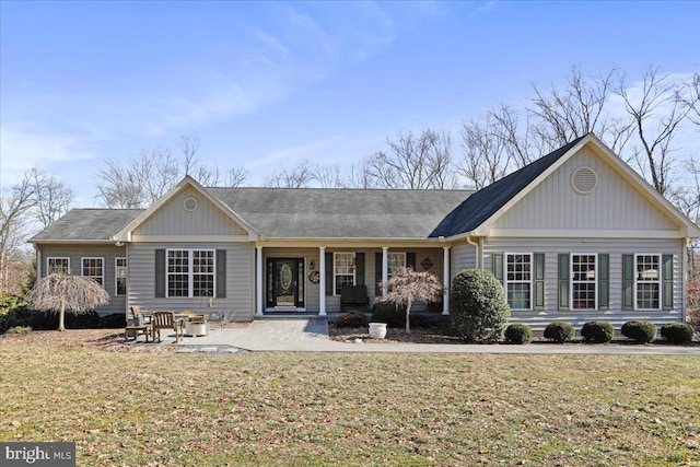 back of house featuring covered porch, a lawn, and a patio