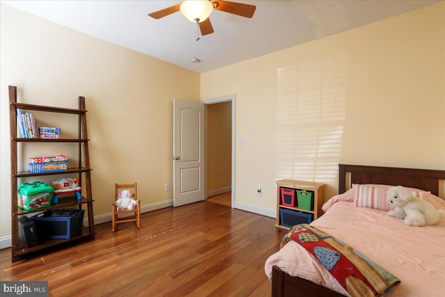 bedroom featuring ceiling fan, baseboards, and wood finished floors