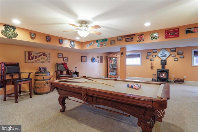 game room featuring baseboards, a ceiling fan, a wood stove, carpet, and recessed lighting