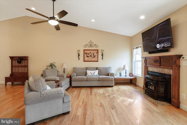 living area with vaulted ceiling, light wood-style flooring, and baseboards