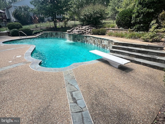 view of swimming pool featuring a patio area, fence, a diving board, and a fenced in pool