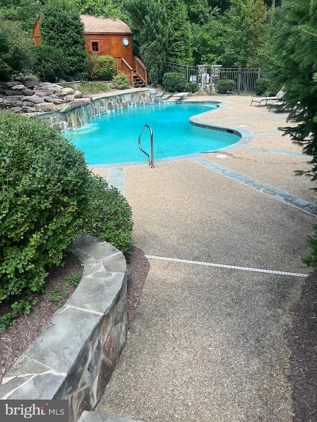 community pool featuring a patio area and fence