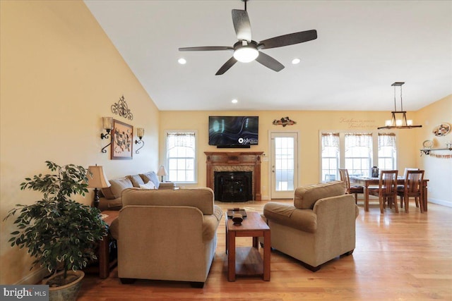 living room with light wood-style floors, a wealth of natural light, a high end fireplace, and recessed lighting