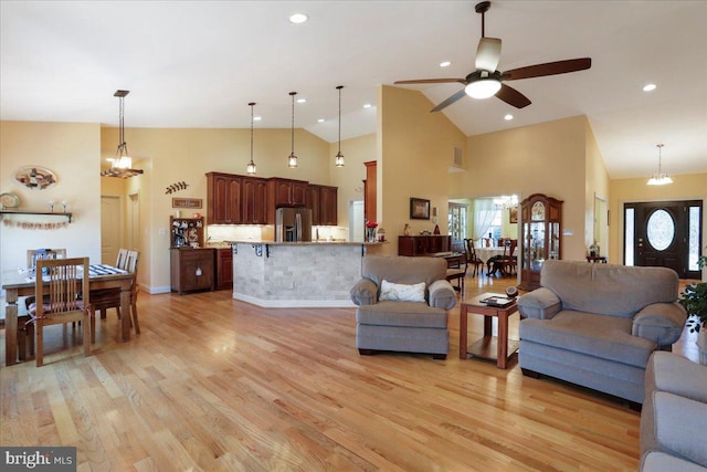 living area with high vaulted ceiling, light wood finished floors, and a wealth of natural light