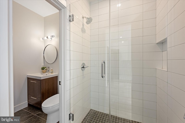 bathroom with vanity, toilet, a stall shower, and tile patterned flooring