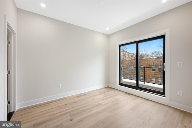 spare room featuring recessed lighting, baseboards, and light wood-type flooring