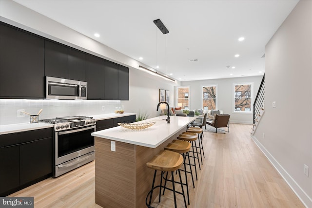 kitchen featuring appliances with stainless steel finishes, modern cabinets, and dark cabinetry