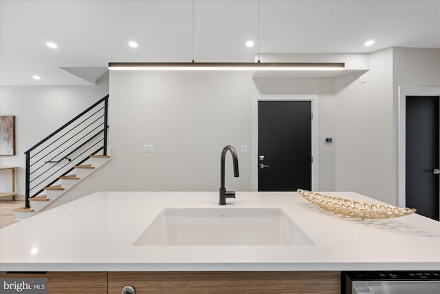 kitchen with stainless steel dishwasher, light countertops, recessed lighting, and a sink