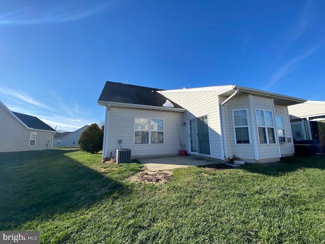 rear view of house featuring a patio, central AC unit, and a lawn