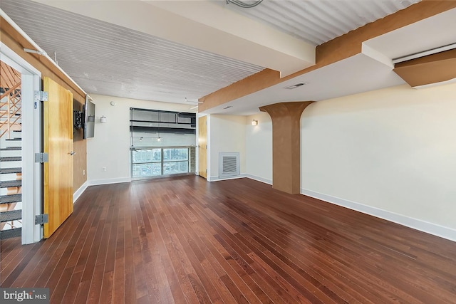 spare room with hardwood / wood-style floors, visible vents, and baseboards