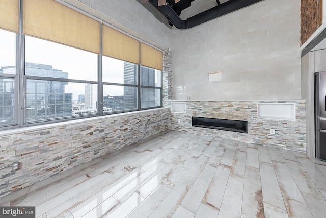 unfurnished living room featuring a view of city and light wood finished floors