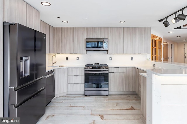 kitchen featuring light brown cabinetry, appliances with stainless steel finishes, modern cabinets, and a sink