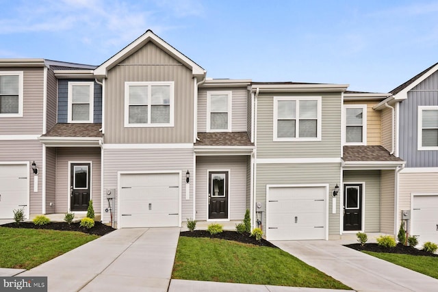 multi unit property featuring concrete driveway, a shingled roof, board and batten siding, and an attached garage