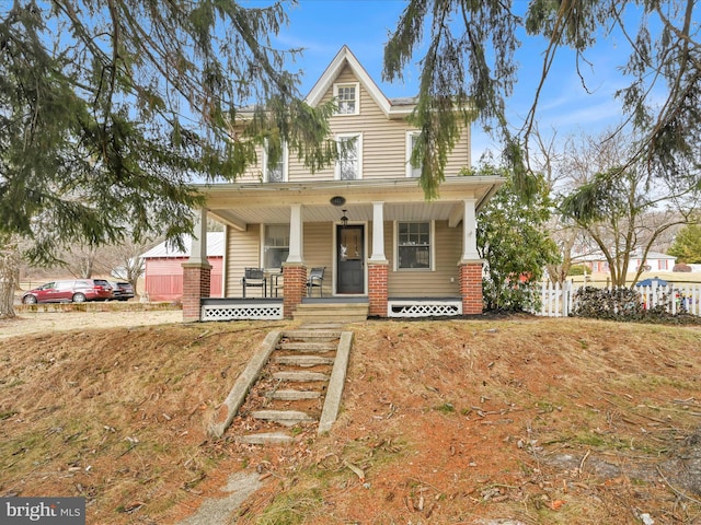 view of front of home with a porch and fence