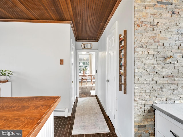 hall with dark wood finished floors, ornamental molding, a baseboard heating unit, wooden ceiling, and baseboard heating