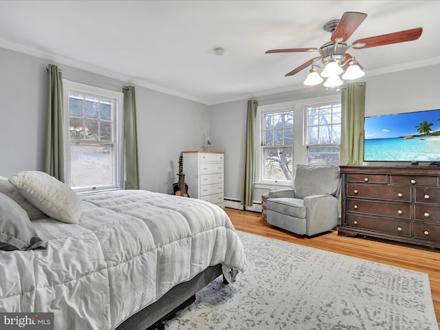 bedroom with baseboard heating, multiple windows, light wood-type flooring, and crown molding