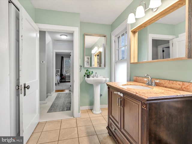 bathroom with tile patterned floors, baseboards, and two sinks