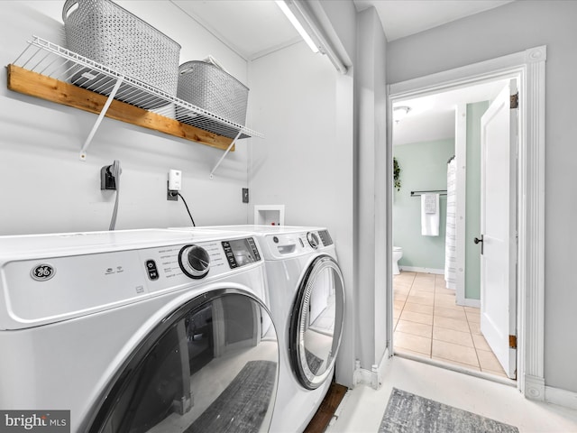 laundry room with laundry area, light tile patterned flooring, baseboards, and independent washer and dryer