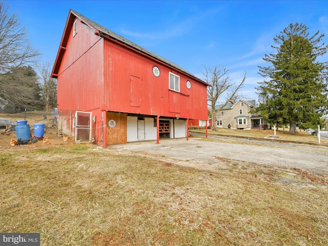 view of barn featuring a lawn and driveway