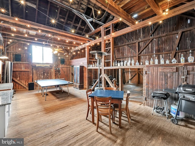 interior space featuring vaulted ceiling, wooden walls, and hardwood / wood-style floors