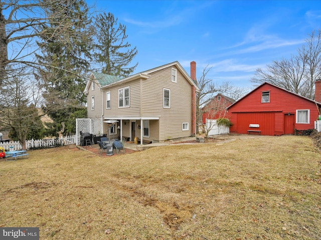 back of property featuring a patio, a chimney, a yard, and fence