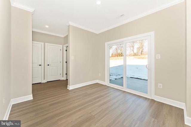 unfurnished room with crown molding, light wood-style flooring, and baseboards