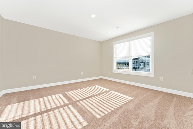 carpeted empty room featuring baseboards