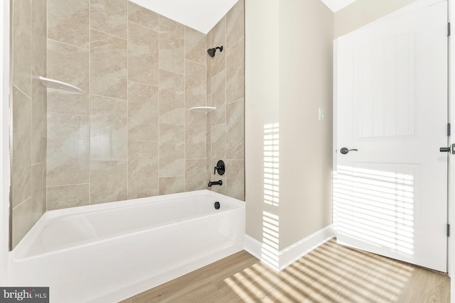 full bath featuring baseboards, wood finished floors, and bathing tub / shower combination