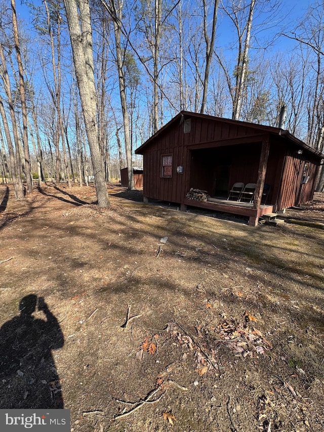 view of side of property with board and batten siding and an outbuilding