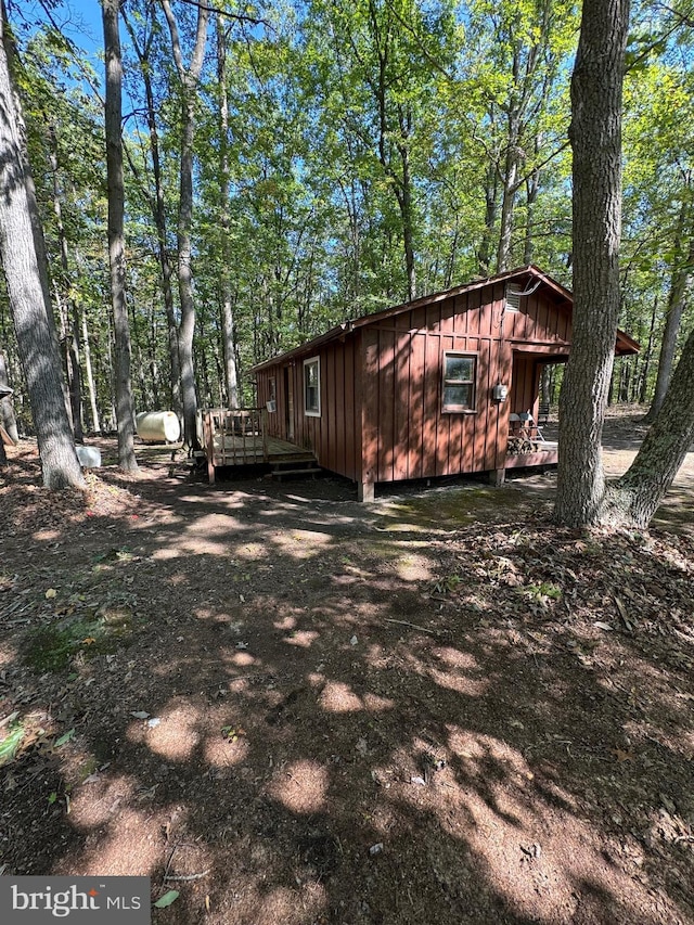 view of property exterior with board and batten siding and a wooden deck