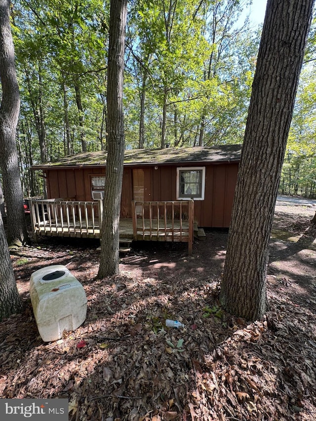 rear view of house with board and batten siding and a wooden deck