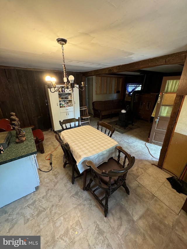 dining space featuring wood walls and an inviting chandelier