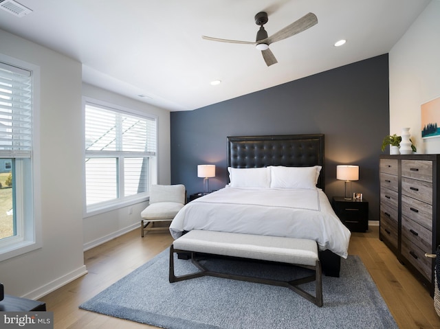 bedroom with visible vents, ceiling fan, lofted ceiling, and wood finished floors