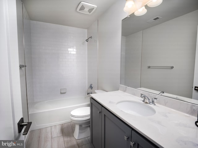 bathroom featuring vanity, toilet, wood finished floors, and visible vents