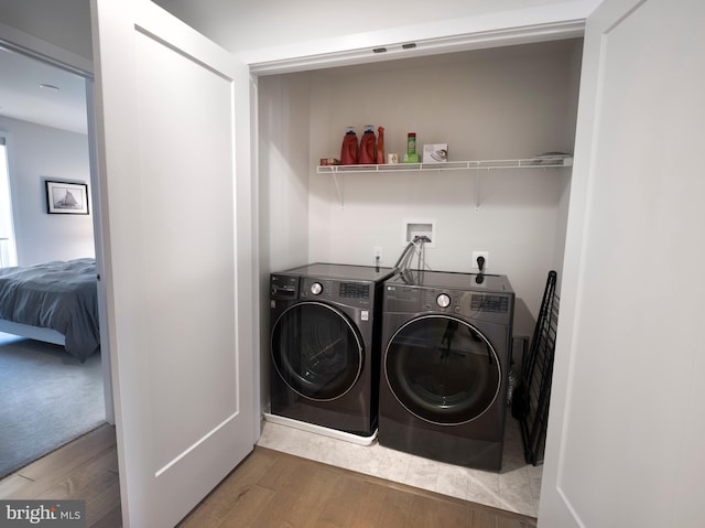 laundry area with wood finished floors, laundry area, and washing machine and clothes dryer