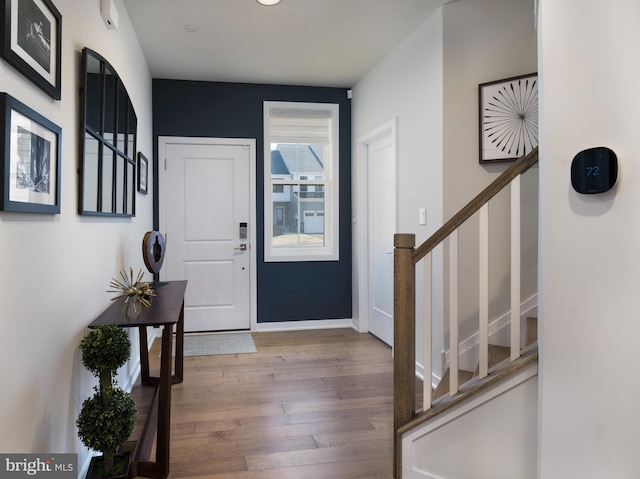 entryway featuring stairs, baseboards, and wood finished floors