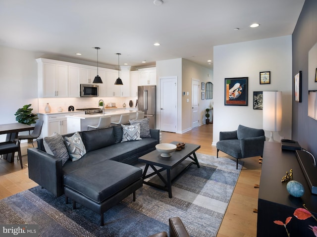 living room featuring recessed lighting, light wood-type flooring, and baseboards