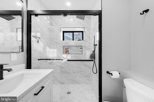 full bath with toilet, vanity, and a marble finish shower